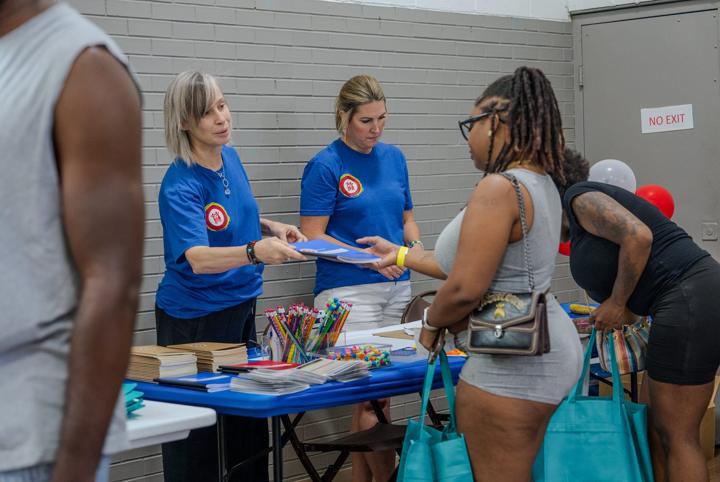 Partner volunteers welcoming families at their table