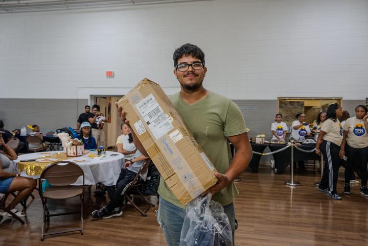 A young dad carrying home a boxed baby item
