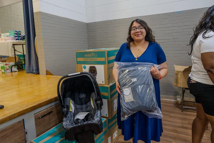 A mom with a new car seat and baby clothing
